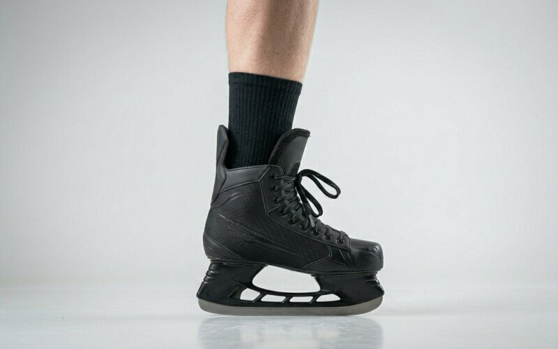 heel lifting out of a hockey skate that is too big, with the sock visible above the back of the boot